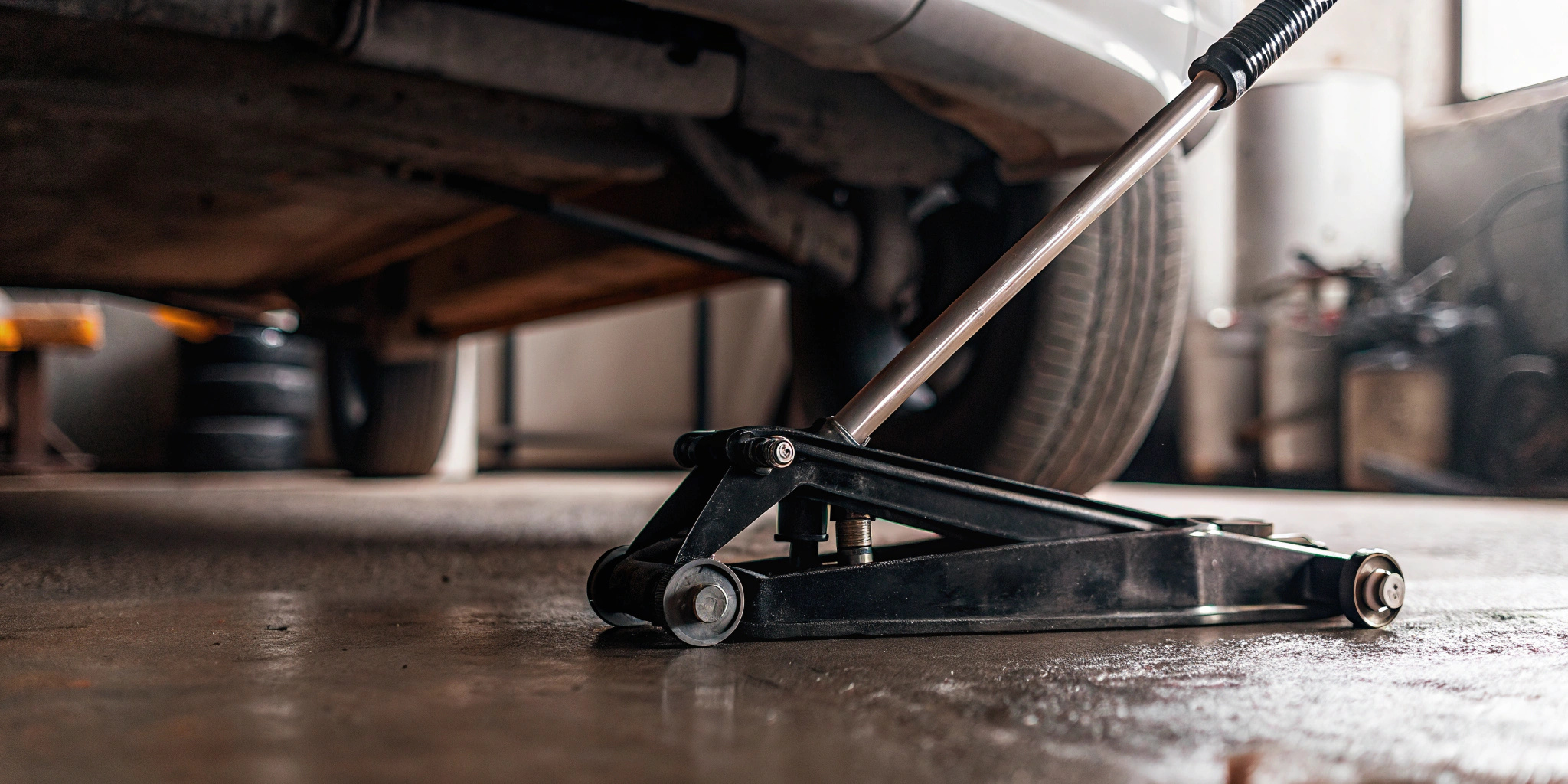 A hydraulic bottle jack on a clean concrete floor.